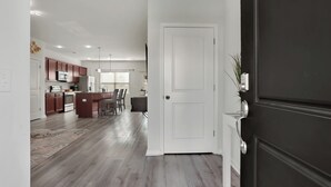 Een moderne keuken met houten kastjes, een centraal eiland en hanglampen.