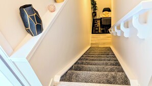 A staircase with a carpeted landing and a white railing. - Luxury and Modern 2 bedroom suite (Balzac)