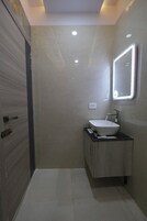 Un baño moderno con un espejo grande, un lavabo y un mueble.