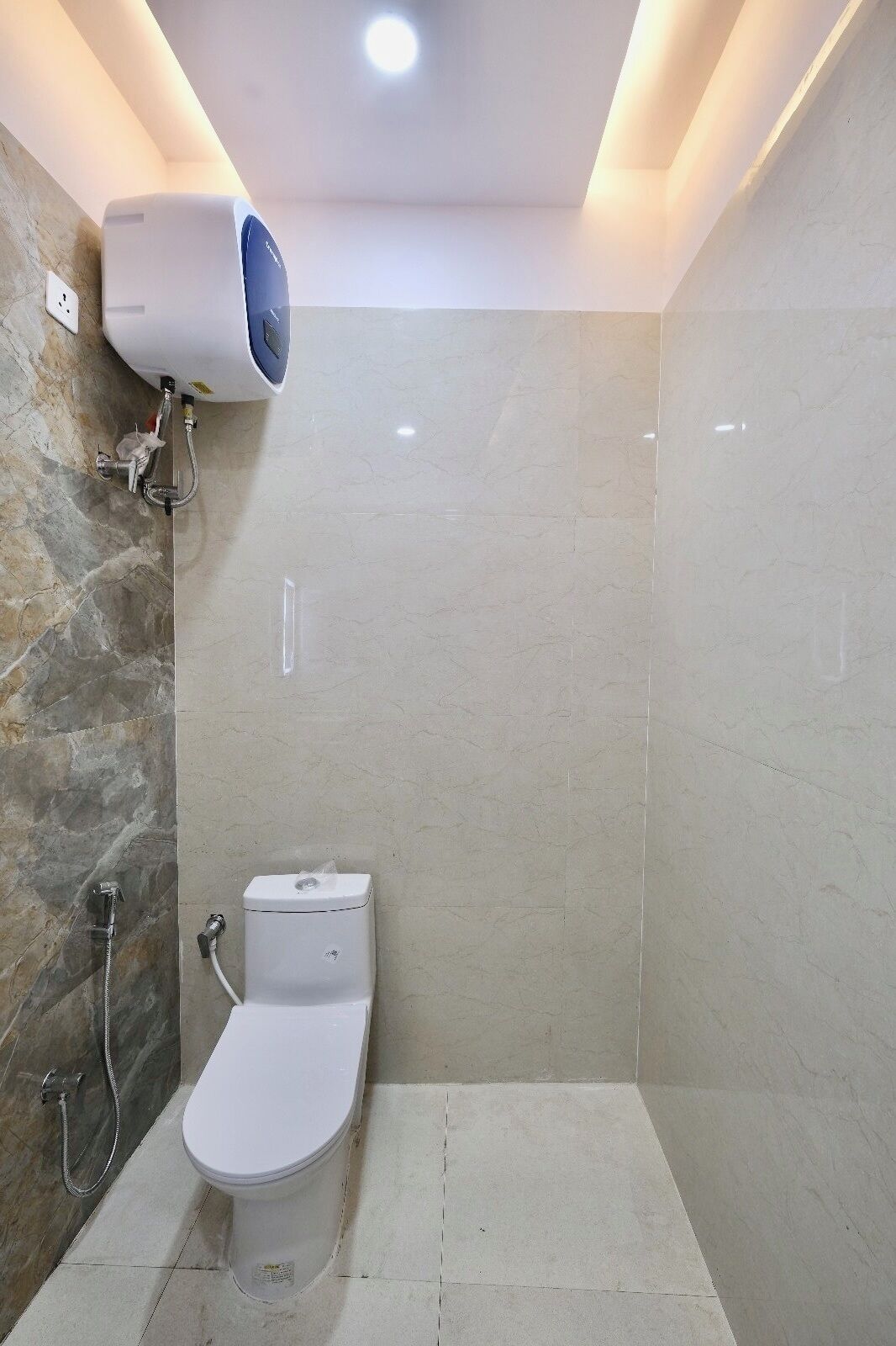 Une salle de bain moderne équipée d’une douche, de toilettes et d’un système de climatisation intégré.