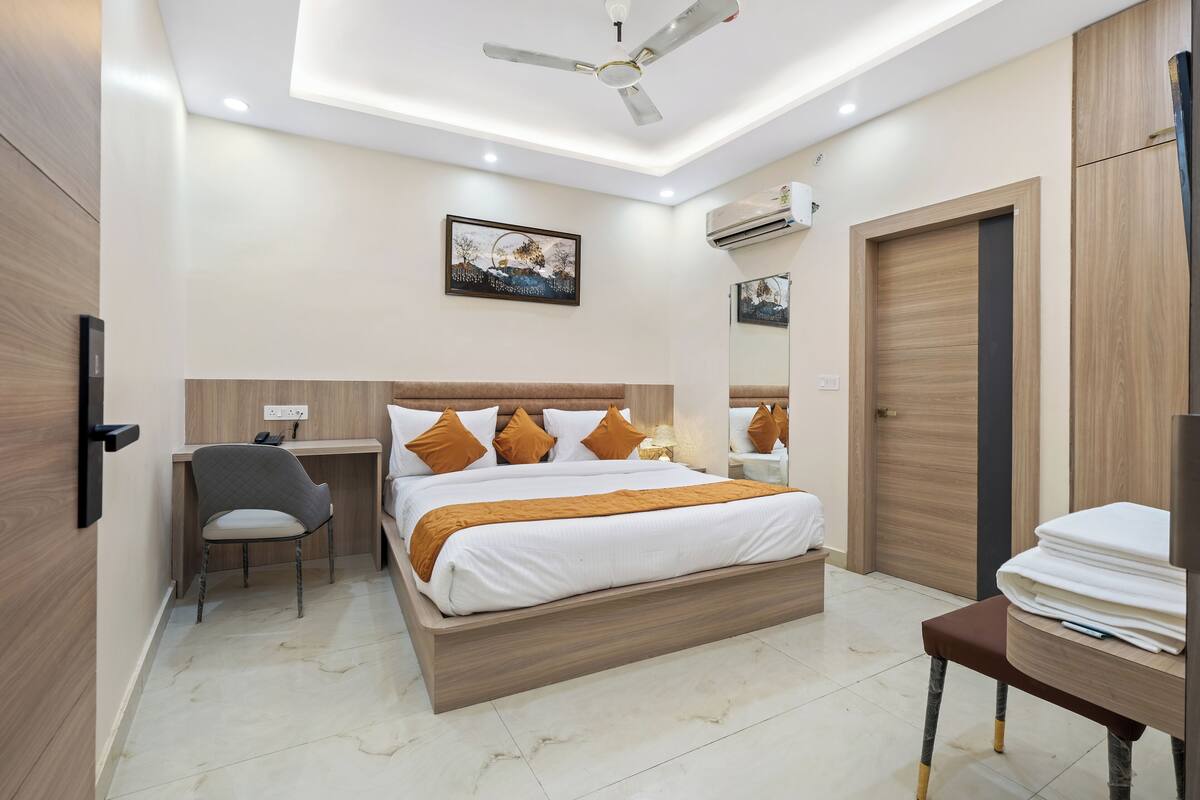 Quarto moderno com cama, escrivaninha, cadeira e guarda-roupa.