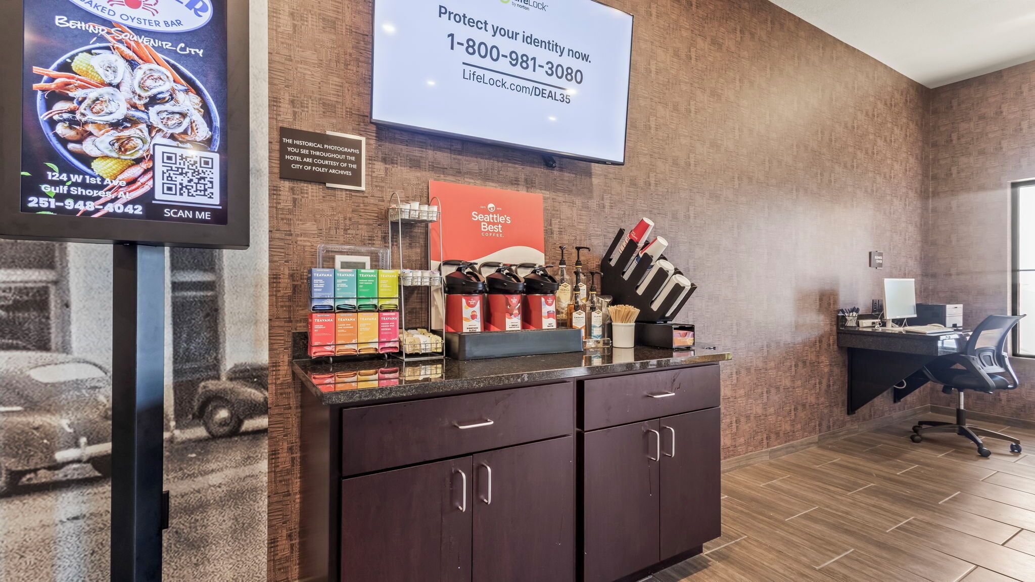 A reception area with a counter displaying coffee and tea, a LifeLock advertisement, and a Seattle's Best Coffee sign.