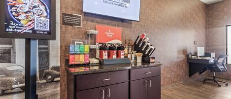 A reception area with a counter displaying coffee and tea, a LifeLock advertisement, and a Seattle's Best Coffee sign.