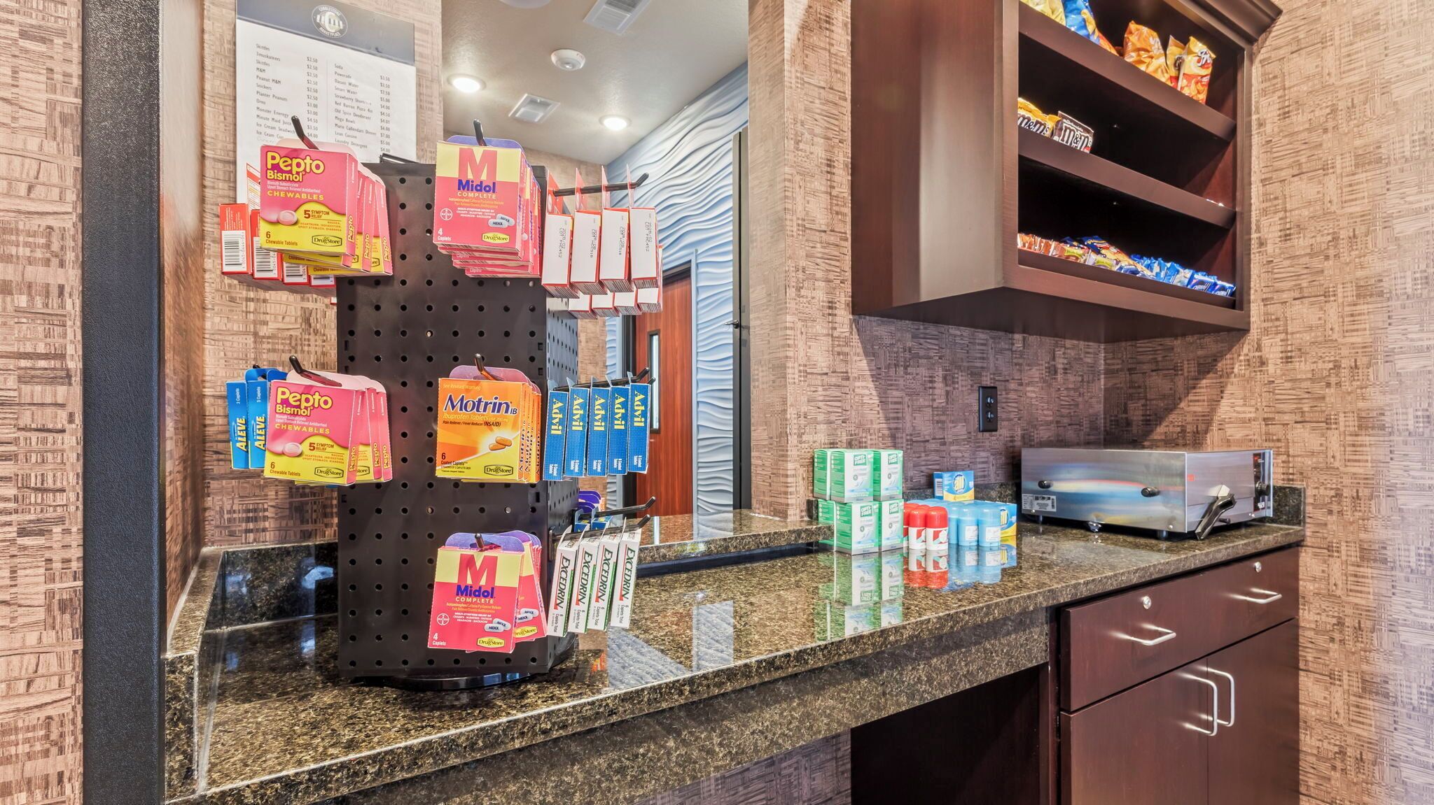 A pharmacy counter with various medications and health products displayed.