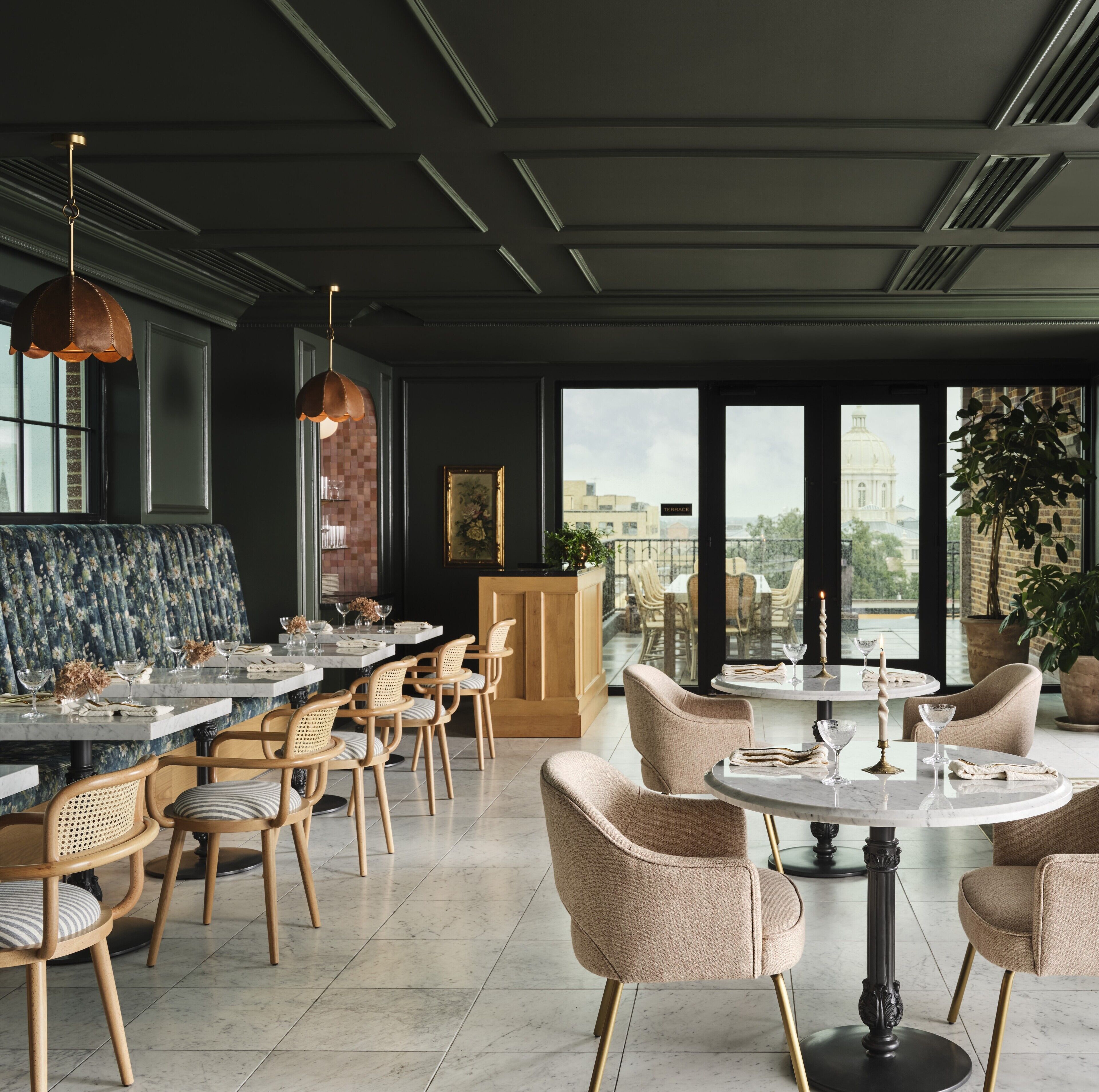 A modern dining area with a mix of seating options, including bar stools and cushioned chairs, arranged around a central table.