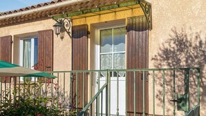 A building with a traditional facade, a wooden door, and a window with a decorative screen. - Lovely home in Chassiers (Chassiers)