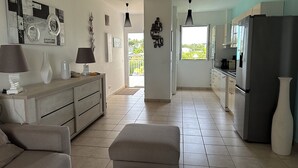 A modern kitchen with a dining area, featuring a sofa, a coffee table, and a dining table.