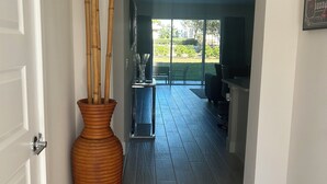 A hallway with a large wooden vase, a glass door, and a view into a dining area with a glass partition. - Charming 3-bedroom townhome with WiFi, AC in Reunion Resort, Kissimmee, FL
 (Kissimmee)