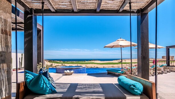 A swing chair with cushions, a hot tub, and a view of the ocean and golf course. - Quivira/Cabo Golf Course Villa W/Awesome OceanView, Infinity Pool on Fairway 18  (Cabo San Lucas)
