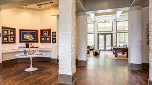 A modern lobby with a pool table, framed pictures on the wall, and a reception desk.