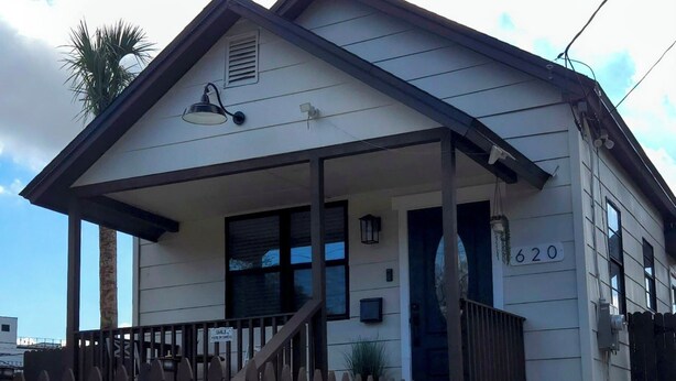 A single-story house with a porch, a number '620' on the side, and a wooden fence in front.