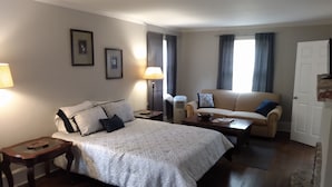 Une chambre d’hôtel avec un lit, un canapé, une table et une lampe.
