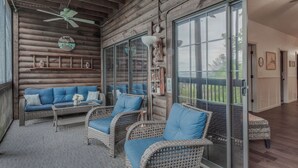 A log cabin-style room with wicker furniture, a ceiling fan, and a view of the outdoors. - 2BR Village At Indian Point 705 near SDC-Free Tickets Daily up to $500 Value (Branson)