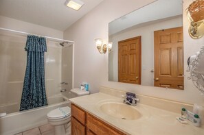 A bathroom with a bathtub, toilet, sink, and a large mirror. - 2BR Village At Indian Point 1007 near SDC-Free Tickets Daily  up to $500 (Branson)