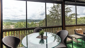 A glass-top table with wicker chairs and a view of a landscape through large windows. - 2BR Village At Indian Point 1208 near SDC - Free Tickets Daily up to $500 (Branson)