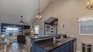 A spacious living room with a large window, a fireplace, and a dining area. - 2BR Village At Indian Point 1212 near SDC - Free Tickets Daily up to $500 (Branson)
