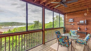 A wooden deck with a glass enclosure, a ceiling fan, and a table with chairs. - 2BR Village At Indian Point 1307 near SDC - Free Tickets Daily up to 500 (Branson)