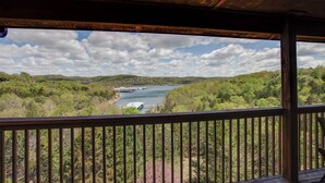 A wooden deck with a view of a river and surrounding greenery. - 2BR+Loft Village At Indian Point 1509 near SDC- Free Tickets Daily up to $500 (Branson)