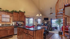 A spacious kitchen with wooden cabinets, a large island, and a dining area with a chandelier. - 2BR+Loft Village At Indian Point 1509 near SDC- Free Tickets Daily up to $500 (Branson)