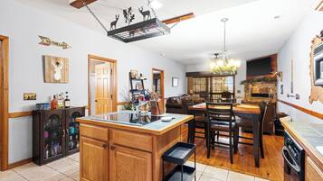 Een ruime keuken met houten kastjes, een centraal eiland en een eethoek met stoelen en een tafel.