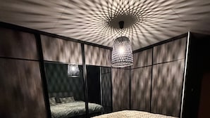 Ein Schlafzimmer mit einem Bett, einer Hängelampe und einer Wand mit Muster.