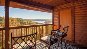 A wooden cabin with a balcony overlooking a lake and forest. - 2BR+Loft Village At Indian Point 1910 near SDC- Free Tickets Daily up to $500 (Branson)