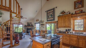 A spacious kitchen with wooden cabinets, a central island, and a dining area with chairs and a table.