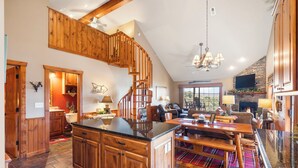 A spacious kitchen with wooden cabinets, a central island, and a dining area with a fireplace. - 2BR+Loft Village At Indian Point 1712 near SDC -Free Tickets Daily up to $500 (Branson)