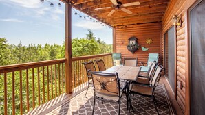 A wooden deck with a table and chairs, a ceiling fan, and a view of trees. - 2BR Village At Indian Point 1803 near SDC - Free Tickets Daily up to $500 (Branson)