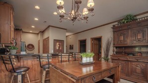 A spacious kitchen with wooden cabinets, a central island with bar stools, and a chandelier. - 2BR Village At Indian Point 1904 near SDC - Free Tickets Daily up to $500 (Branson)