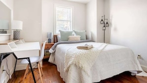 Un dormitorio con cama, escritorio y silla.