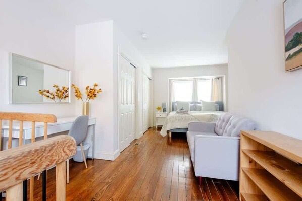 A bedroom with a bed, bedside table, and a window.