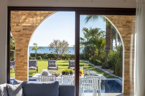 Ein Zimmer mit Blick auf einen Pool, Sitzmöglichkeiten im Freien und einem gepflegten Garten.