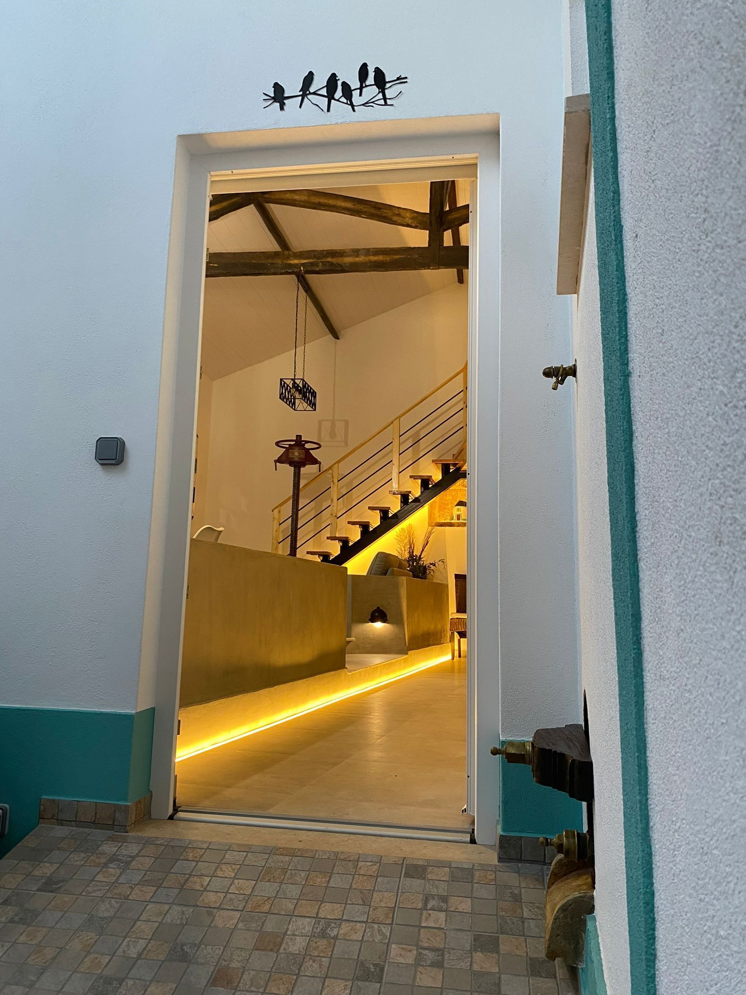 A hallway with a staircase leading to a landing.
