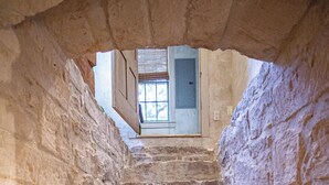 A stone staircase leading to a room with a window and a door. - Charming Hill Country Getaway in Texas (Fredericksburg)