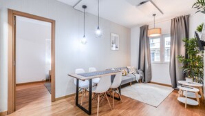 A modern living room with a dining table, chairs, a sofa, and a small side table. - C Plaza de Espa a 3A (Madrid)