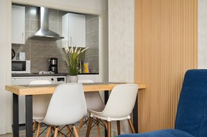 Une cuisine moderne avec un coin repas, comprenant une table avec des chaises et un canapé bleu.