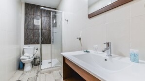 A modern bathroom with a glass-enclosed shower, a white sink with a wooden vanity, and a toilet. - C Plaza de Espa a 4B (Madrid)