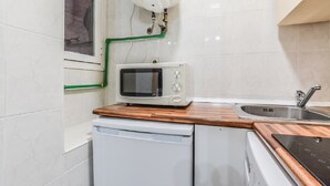 A compact kitchen with a microwave, a sink, and a dishwasher. - C Plaza de Espa a 4B (Madrid)