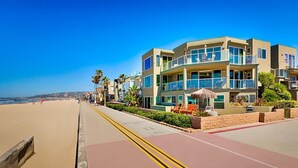 Ein Hotel direkt am Strand mit mehreren Etagen, Außenbereich zum Sitzen und freiem Blick auf den Strand.