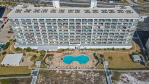 Un hotel de diversos pisos amb nombroses galeries, una piscina i una zona d'aparcament.