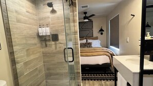 Une salle de bain moderne avec une douche à parois de verre, un lavabo blanc et des toilettes.
