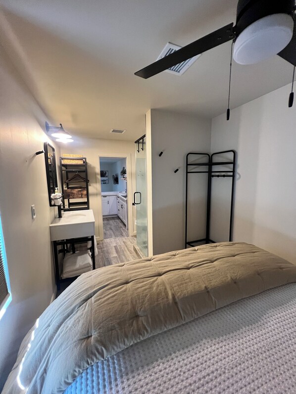 A bedroom with a bed, a ceiling fan, a bedside table, and a mirror. - Cozy 1-bedroom apartment in charming Scottsdale with WiFi, AC (Scottsdale)
