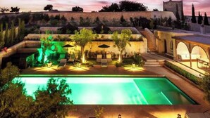 A pool area with a view of a historic building in the background. - Villa Riad Dharma (Essaouira)
