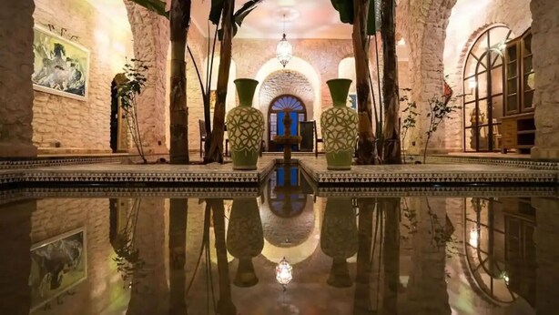 A spacious indoor area with a reflective floor, stone walls, and a central archway. - Villa Riad Dharma (Essaouira)