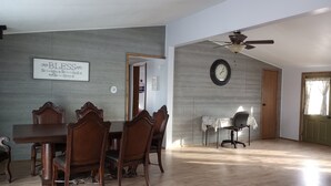 A dining area with a wooden table and chairs, a clock on the wall, and a ceiling fan. - Ranches, Lakes, Mountains & the Great Outdoors. Bring Your Horses Pasture Onsite (Helena)