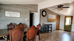 A dining area with a wooden table and chairs, a clock on the wall, and a ceiling fan. - Ranches, Lakes, Mountains & the Great Outdoors. Bring Your Horses Pasture Onsite (Helena)