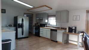 A compact kitchen with a refrigerator, stove, dishwasher, and a microwave. - Ranches, Lakes, Mountains & the Great Outdoors. Bring Your Horses Pasture Onsite (Helena)