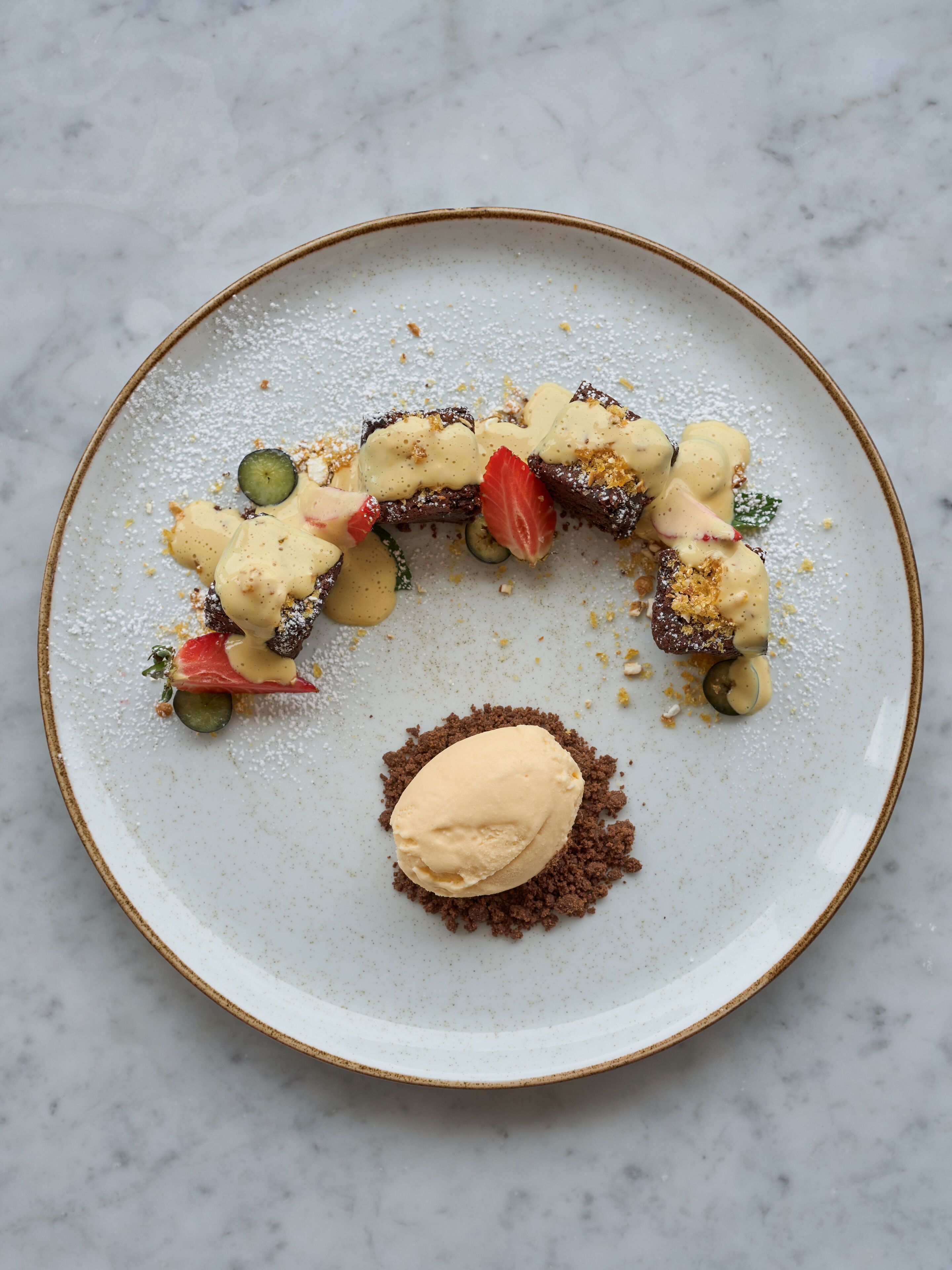 A dessert plate with a scoop of ice cream and various toppings.