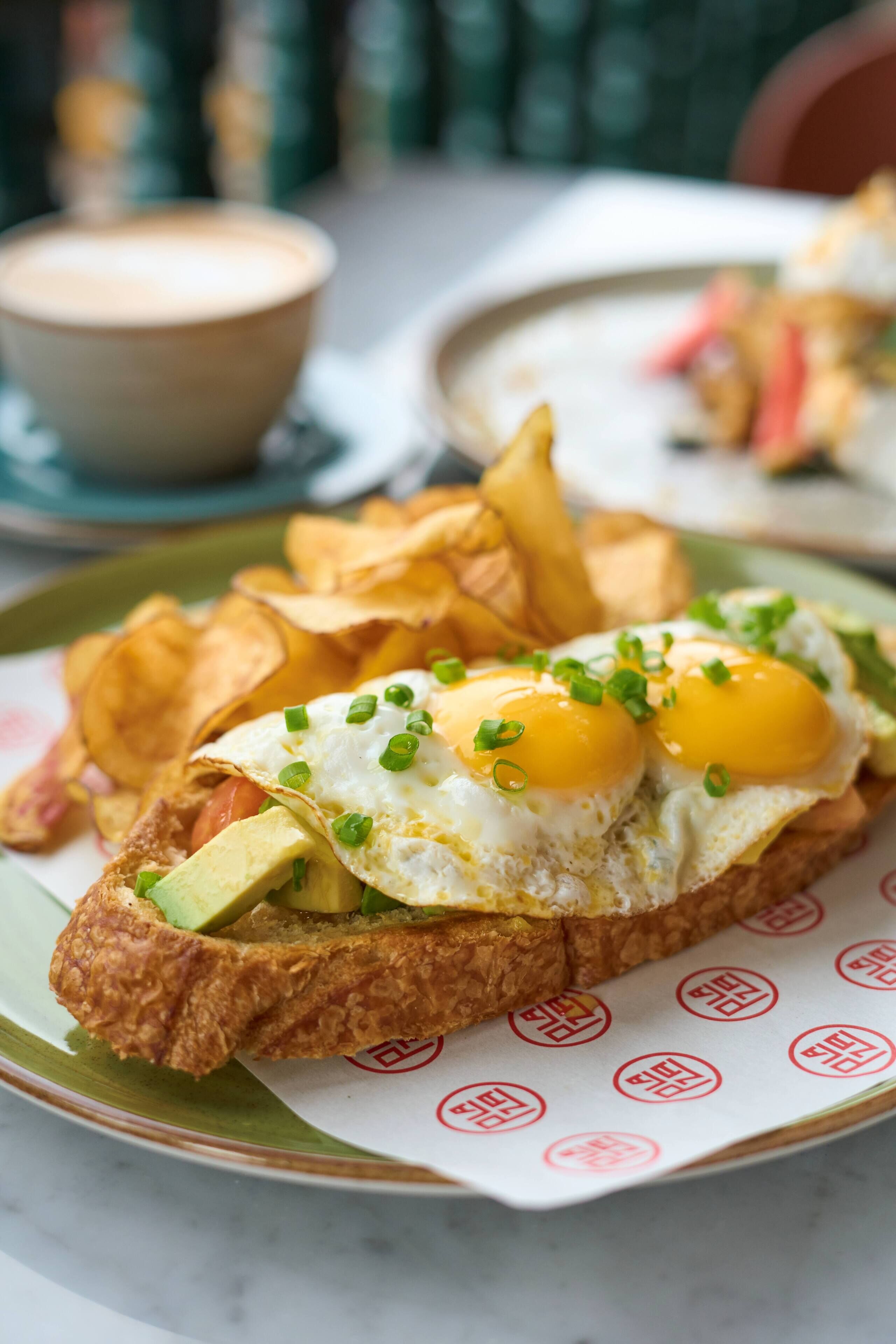 Un plato de desayuno con huevos, aguacate y papas fritas.